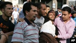 រូបឯកសារ៖ បាតុករលើកបុរសម្នាក់ ដែលរងរបួសអំឡុងពេលប៉ះទង្គិចគ្នាជាមួយប៉ូលិស អំឡុងពេលបាតុកម្មមួយក្នុងបរិបទរដូវផ្ការីកនៅក្រុង Casablanca ប្រទេស​ម៉ារុក កាល​ពីថ្ងៃទី២៩ ខែឧសភា ឆ្នាំ២០១១។ 