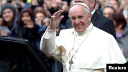 Pope Francis waves as he leaves at the end of his mass at the Church of the Most Holy Name of Jesus in Rome, Jan. 3, 2014. 