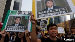 香港民主示威者舉著香港特首梁振英像和質問他的口號遊行（2014年10月22日）