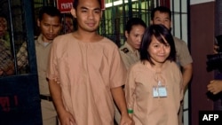 និស្សិត​ Patiwat Saraiyaem អាយុ​២៣​ឆ្នាំ​ (ឆ្វេង)និង​សកម្មជន Porntip Mankong អាយុ​២៦​ឆ្នាំ​ (ស្តាំ) ត្រូវ​​​មន្ត្រី​សន្តិសុខ​នាំ​ខ្លួន​​ក្រោយ​ពី​មាន​ការ​ប្រកាស​សាលក្រម​របស់​តុលាការ​​ព្រហម្មទណ្ឌ​នៅ​រាជធានី​បាងកក​កាល​ពី​ថ្ងៃ​ច័ន្ទ​ទី​២៣ ខែ​កុម្ភៈ ឆ្នាំ​២០១៥។