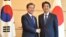 South Korea's President Moon Jae-in, left, shakes hands with Japan's Prime Minister Shinzo Abe before their meeting at Abe's official residence in Tokyo, May 9, 2018. 