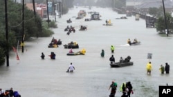 Rescue boats fill a flooded street as flood victims are evacuated during Tropical Storm Harvey, Aug. 28, 2017, in Houston. (AP Photo/David J. Phillip)