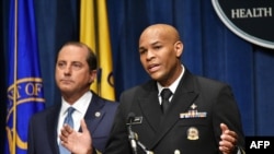 U.S. Surgeon General, Vice Admiral Jerome Adams, flanked by Health and Human Services Secretary Alex Azar, briefs the media on the release of a warning against marijuana use by by adolescents and pregnant women, in Washington, Aug. 29, 2019. 