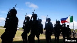 FILE - Soldiers march at Guiuan airport to take part in the welcoming ceremony for visiting French President Francois Hollande in Guiuan, Samar, a town that was devastated by Typhoon Haiyan in central Philippines, February 27, 2015.