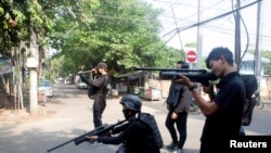 FILE - Demonstrators hold homemade pipe air guns during a protest against the military coup in Yangon, Myanmar, April 3, 2021.