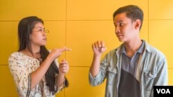 Seng Theary (left) talk to her colleague, Phem Vengheng, who has a hearing disability, using sign language at their workplace, Socials Coffee, in Phnom Penh, Cambodia, May 23, 2020. (Hean Socheata/VOA Khmer)