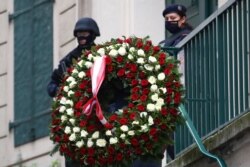 Un hombre lleva una corona de flores para el lugar donde el lunes por la noche hubo un mortal ataque terrorista en el centro de Viena. Martes 3 de noviembre de 2020.
