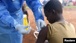 A Congolese health worker administers Ebola vaccine to a boy who had contact with an Ebola sufferer in the village of Mangina in North Kivu province of the Democratic Republic of Congo, August 18, 2018. (REUTERS/Olivia Acland)