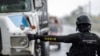 ARCHIVO - Un oficial de la Policía Nacional de Haití detiene a un camión en un control de seguridad en Limonade, Haití, el 27 de abril de 2024.