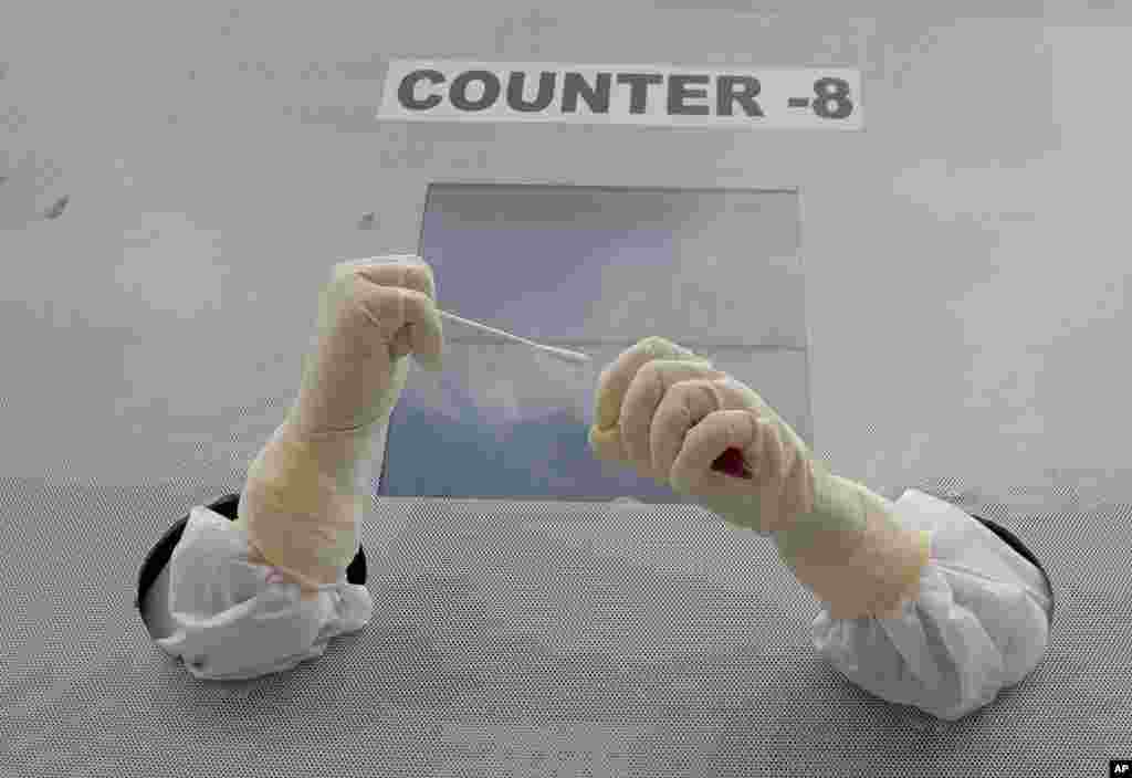 A health worker prepares to collect nasal swab samples for COVID-19 tests at a mobile testing center in Hyderabad, India.