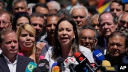 La candidata presidencial opositora María Corina Machado ofrece un discurso a las afueras de su comando de campaña en Caracas, el 29 de enero de 2024, flanqueada por dirigentes de partidos del antichavismo.