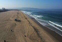 A few people are seen on the beach on the first day of a record heat wave, amid the global outbreak of coronavirus disease, in Hermosa Beach, near Los Angeles, Calif., Sept. 4, 2020.