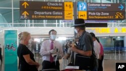 Warga Australia diperiksa oleh petugas keamanan saat keberangkatan di Bandara Internasional Ngurah Rai, Bali, Rabu, 18 Agustus 2021. Ratusan warga Australia meninggalkan Bali, dalam program repatriasi dari pemerintah Australia. (AP Photo//Firdia Lisnawati)