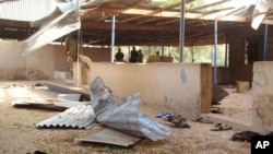 Les troupes nigérianes, à l'arrière, assurent la sécurité dans la zone où une bombe a explosé à l'Université de Maiduguri, au nord-est du Nigéria, à Maiduguri, Nigeria, 16 janvier 2016. 