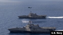 美军“蒙哥马利”号（USS Montgomery）（上）和“吉福兹”号（USS Gabrielle Giffords）濒海战斗舰2020年1月20日在一架海鹰直升机的掩护下在南中国海执行任务。