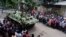 An armored vehicle drives past members of the press after an operation against militants who took hostages at a restaurant popular with foreigners in Dhaka, Bangladesh, Saturday, July 2, 2016.