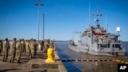 Un grupo de soldados de la 7a. Brigada de Transporte se despiden de la tripulación del USAV Monterrey mientras se aleja del muelle y emprende una misión humanitaria hacia la Franja de Gaza, el martes 12 de marzo de 2024, en la Base Conjunta Langley-Eustis en Hampton, Virginia. 