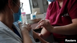 Seorang perempuan menerima suntikan vaksin COVID-19 produksi Oxford-AstraZeneca di Suresnes, dekat Paris (foto: dok). Perancis memiliki tingkat "skeptisisme" warga terhadap vaksin tertinggi di dunia. 