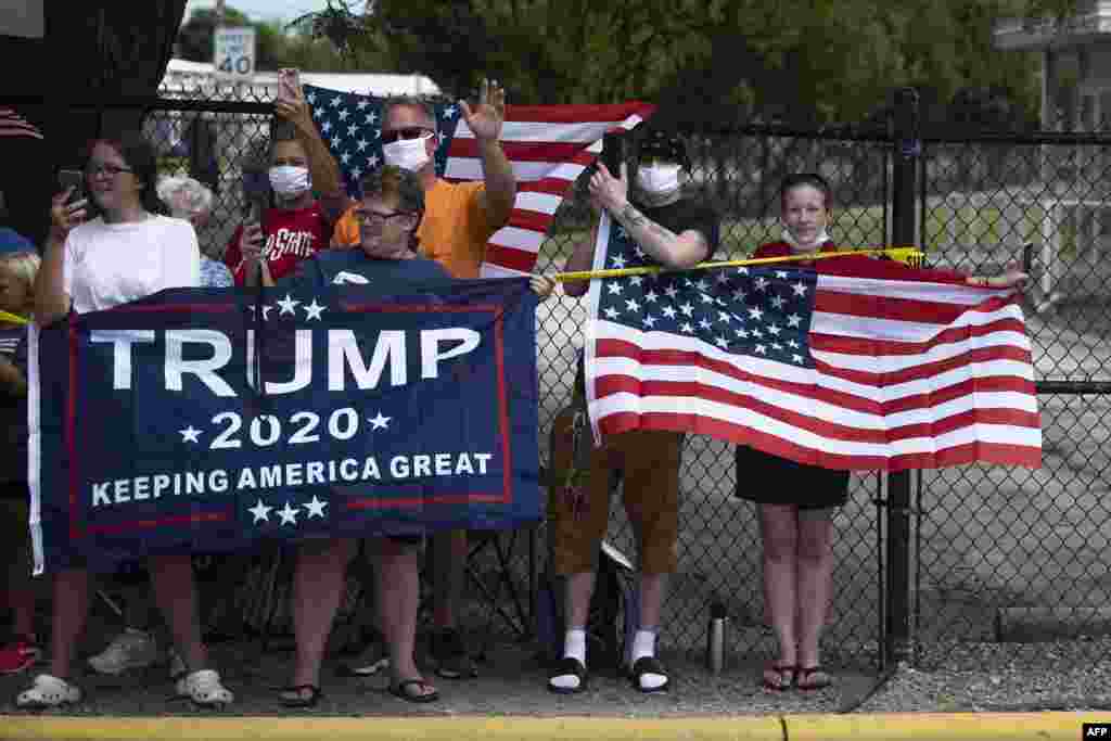 ក្រុមអ្នកគាំទ្រលោកប្រធានាធិបតី Donald Trump កាន់ទង់ជាតិអាមេរិកនិងបដា ខណៈលោក Trump ធ្វើដំណើរទៅដល់រោងចក្រ Whirlpool Corporation នៅទីក្រុង Clyde រដ្ឋ Ohio ថ្ងៃទី ៦ ខែសីហា ឆ្នាំ២០២០។