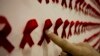 Seorang pria menunjuk sebuah karya seni di pameran seni konseptual tentang HIV/AIDS, sebagai ilustrasi. (Foto: Reuters)