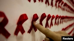 Seorang pria menunjuk sebuah karya seni di pameran seni konseptual tentang HIV/AIDS, sebagai ilustrasi. (Foto: Reuters)