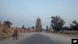 A man looks at graves partially demolished to make way for a new highway through the Northern Cemetery in Cairo, Egypt, Wednesday, July 29, 2020. Preservationists have raised alarm over the government's construction of two highways through historic cemeteries. (AP Photo)