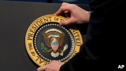 FILE - The Presidential Seal is placed on the podium at Flint Northwestern High School in Flint, Mich., Wednesday, May 4, 2016. (AP Photo/Carolyn Kaster)