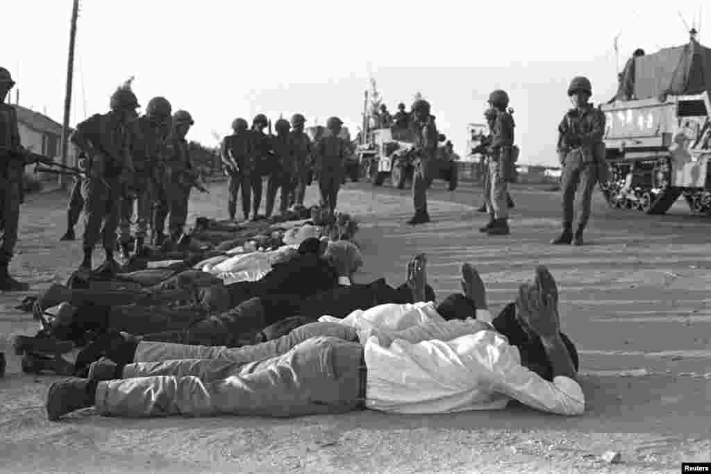 Isroillik zobitlar G'azoda asirlarni qo'riqlamoqda / Israeli soldiers stand guard over prisoners in Rafah in the southern Gaza Strip during the Middle East War, June 5, 1967.