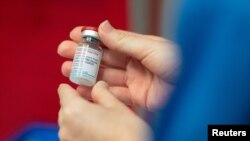 Une infirmière tient un flacon du vaccin Moderna contre la maladie COVID-19 à l'hôpital général Glangwili de Carmarthen, au Pays de Galles, en Grande-Bretagne, le 7 avril 2021. 