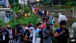 Migrantes que se dirigen al norte hacen fila para tomar un bote, en Bajo Chiquito, provincia de Darién, Panamá, el jueves 5 de octubre de 2023, después de cruzar caminando el Tapón del Darién desde Colombia.