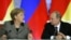 Russian President Vladimir Putin, right, and German Chancellor Angela Merkel speak to each other after a signing ceremony during a Russian-German business forum in the Grand Kremlin Palace in Moscow, Friday, Nov. 16, 2012. 