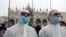FILE - Tourists wear protective face masks at Venice Carnival, which the last two days of, as well as Sunday night's festivities, have been cancelled because of an outbreak of coronavirus, in Venice, Italy, Feb. 23, 2020. 