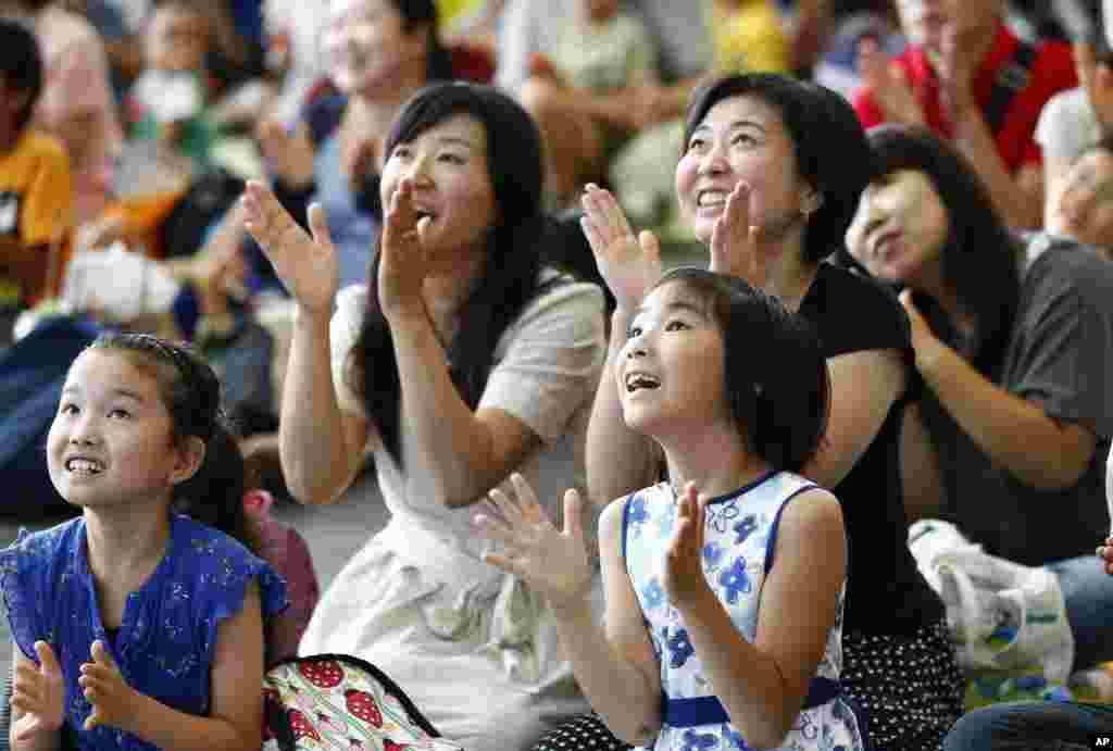 Visitors watch NASA's live broadcast of Soyuz TMA-17M hatch's opening at a public viewing in the National Museum of Emerging Science and Innovation "Miraikan" in Tokyo, Japan, July 23, 2015.