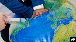 Un grupo de personas trata de "resucitar" al planeta en una manifestación en la cumbre climática COP28 en Dubái, el 3 de diciembre de 2023.