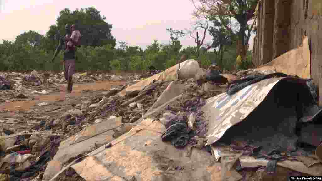 Wani Mutum Da Dan Sa Na Tafiya Cikin Tarkace Kusa Da Sabon Sansanin 'Yan Gudun Hijira Kochogoro Dake Abuja Najeriya &nbsp;