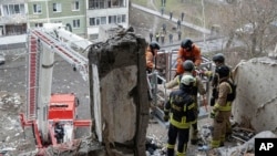 乌克兰紧急情况服务部提供的照片显示，搜救人员在乌克兰苏梅被俄罗斯无人机击中的一座公寓楼废墟寻找遇难平民。(2025年1月30日)