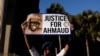ARHIVA - Žena drži transparent "Pravda za Ahmada" ispred sudnice u Brunzviku, 24. novembra 2021.