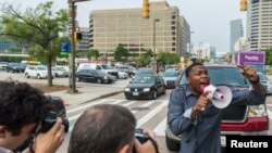 Un manifestant bloque la circulation pendant que d'autres protestaires avancent lors d'une manifestation pour Freddie Gray, jeune noir mort alors qu'il était en détention par police, à Baltimore, Maryland, 2 septembre 2015.