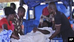 Rescue workers carry an injured person from a transport at St Gerard hospital in Kaduna, Nigeria, June 17, 2012. 