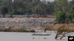 ឯកសារ៖ នៅ​ក្នុង​រូបថត​នៅ​ថ្ងៃ​ទី​២០ ខែ​មិថុនា ឆ្នាំ​២០១៦​នេះ គេ​ឃើញ​ទូក​នេសាទ​មួយ​បើក​កាត់​ក្បែរ​ការដ្ឋាន​ទំនប់ Don Sahong នៅ​ជិត​ព្រំដែន​កម្ពុជា​ឡាវ នៅ​ភូមិ​ព្រះរំកិល ខេត្ត​ស្ទឹងត្រែង។