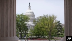 FILE - The Capitol building is seen through the columns on the steps of the Supreme Court in Washington.