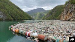 In this photo taken on Tuesday, April 23, 2019, plastic bottles and other garbage float in the river Drina near Visegrad, eastern Bosnia-Herzegovina. (AP Photo/Eldar Emric)