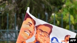 Un partidario del candidato presidencial ecuatoriano por Unidos por la Esperanza, Andrés Arauz, ondea una bandera en una calle de Quito, el 1 de abril de 2021.