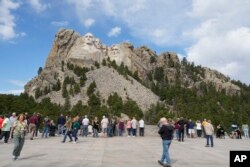 Posjetioci velike skulpture četvorice američkih predsjednika u Nacionalnom memorijalu Maunt Rašmor, 21. septembra 2023. (Foto: AP/David Zalubowski)