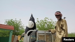 FILE - Fighters from the Islamic militant group the Movement for Unity and Jihad in West Africa ride on a truck in the northeastern Malian city of Gao September 7, 2012.