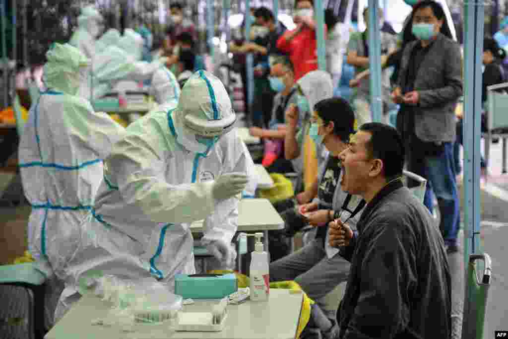 A medical worker takes a swab sample from a resident to be tested for the COVID-19 in Wuhan in China's central Hubei province.&nbsp;Nervous residents of the pandemic epicenter queued up across the city for testing after a new cluster of cases sparked a mass screening campaign.
