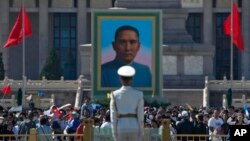 Los visitantes se reúnen cerca de un retrato de Sun Yat-sen, quien es ampliamente considerado como el padre fundador de la China moderna, en la Plaza de Tiananmen durante el período de vacaciones del Primero de Mayo en Beijing, el 30 de abril de 2023.
