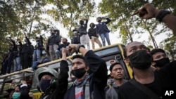 Indonesian students raise their fists and shout slogans during a protest against a controversial omnibus bill on job creation, in Tangerang Indonesia, Wednesday, Oct. 7, 2020. Thousands of Indonesian students and laborers protested on Wednesday…