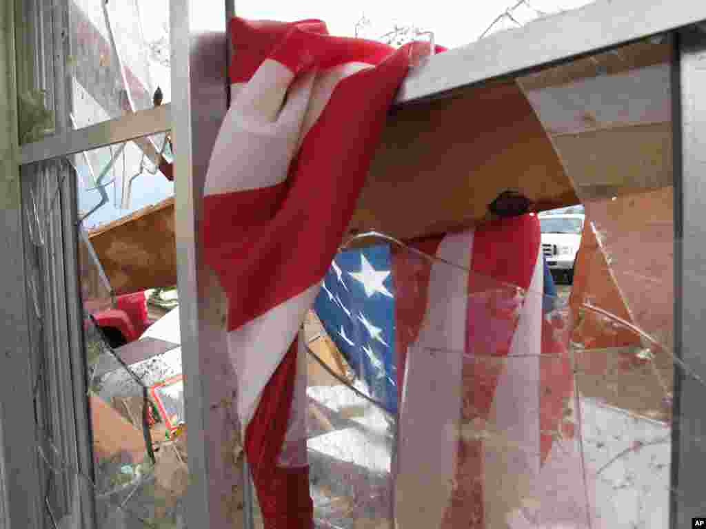 A soggy American flag hangs in a broken window at Wayne Osmus' home in Moore, Oklahoma. Osmus' family hid in a closet Monday after winds kept them from taking refuge in the storm shelter. 