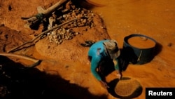 FILE - A wildcat gold miner, or garimpeiro, uses a tool and mercury to search for gold at a wildcat gold mine, also known as a garimpo, at a deforested area of the Amazon rainforest near Crepurizao, Para State, Brazil, August 5, 2017. (REUTERS/Nacho Doce/File Photo)